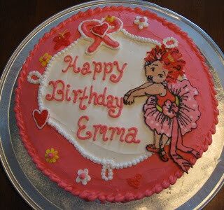 A photograph of a pink and white fancy nancy cake made using icing sheet transfers to put a picture on a cake