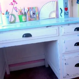 The final photo of a DIY desk makeover project shows a white and blue desk for a girls room, staged with desk accessories