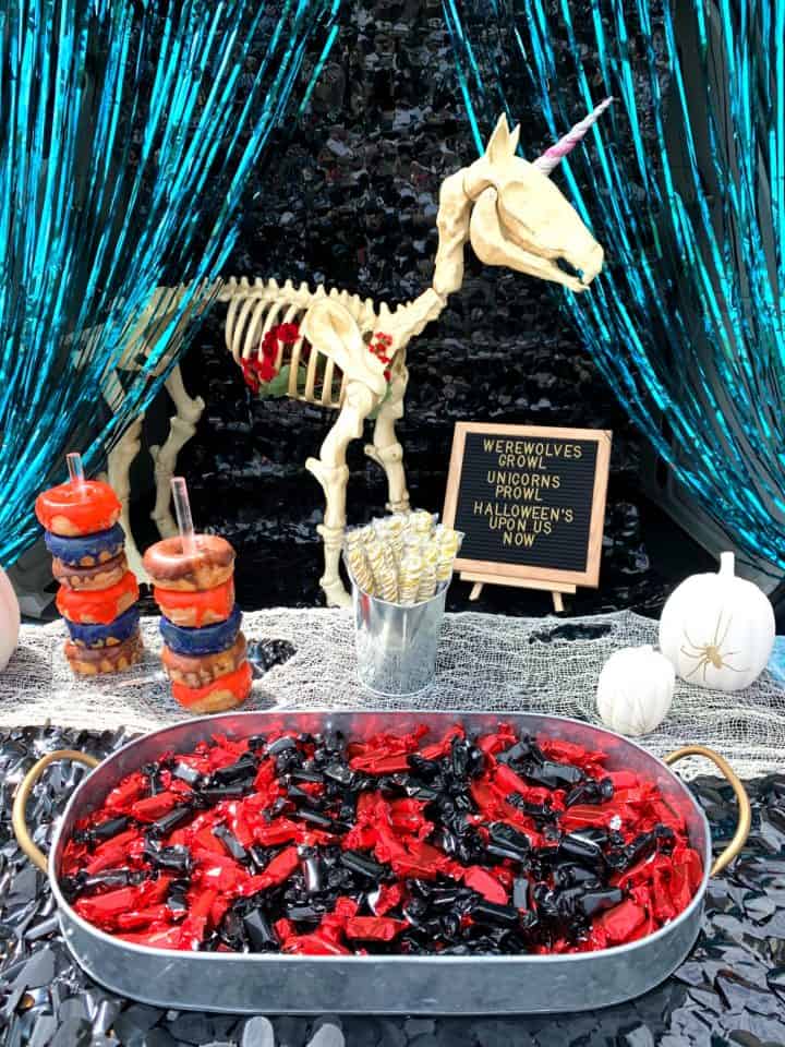tray of red and black candy with a unicorn in the background for trunk or treat