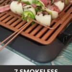 A Pinterest pin with an image of gilled meat and vegetables being cooked on a smokeless indoor grill. The text says, “7 Smokeless Indoor Grills.”
