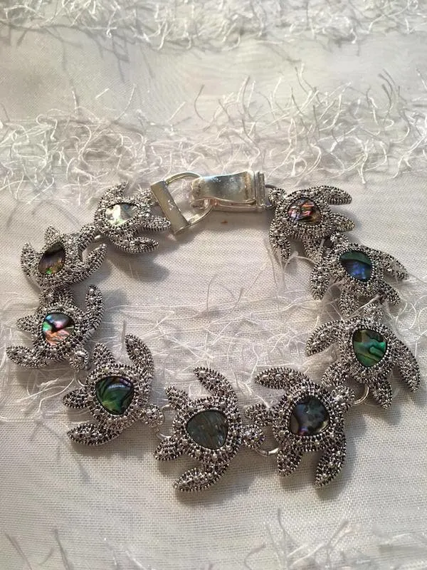 A silver turtle bracelet made of silver turtle and crystal shapes  linked together