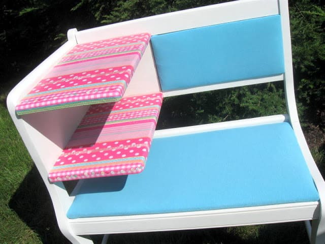 An after photo showing an upcycled bench for a girls room. The bench is white, blue, and pink