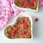 Chocolate oatmeal served in a heart shaped bowl and garnished with red hearts made from melting wafers