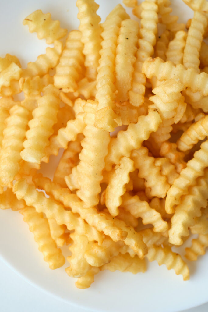 A close up of crinkle cut fries on a plate