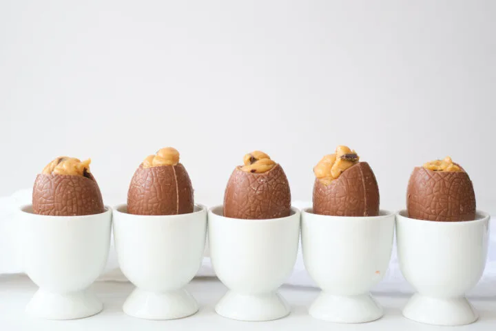 A row of peanut butter filled easter eggs in which egg cups against a white background