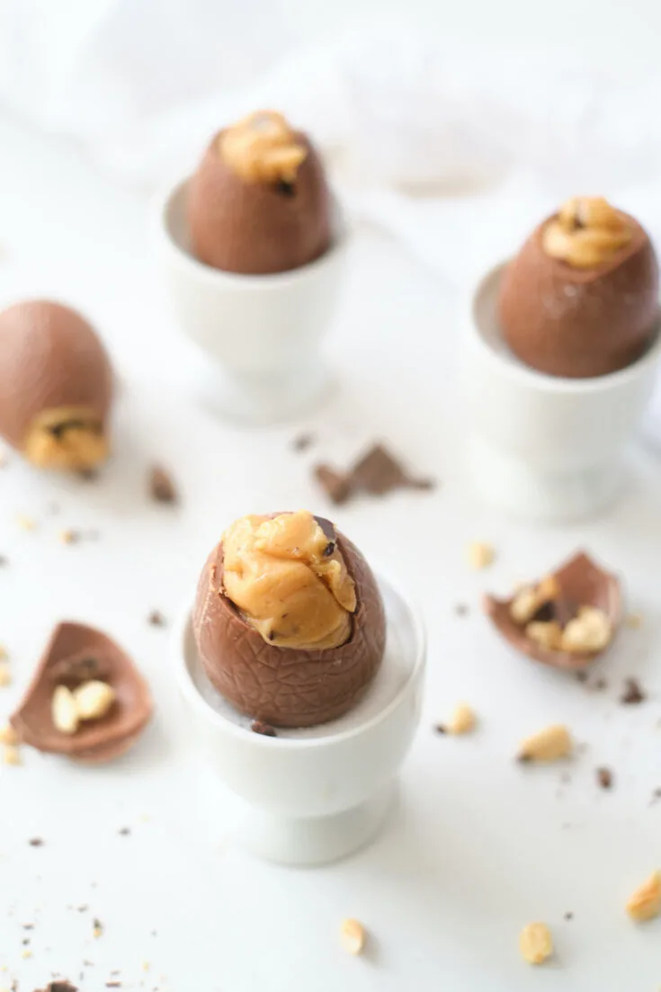 Homemade peanut butter easter eggs with chocolate chips in white egg cups