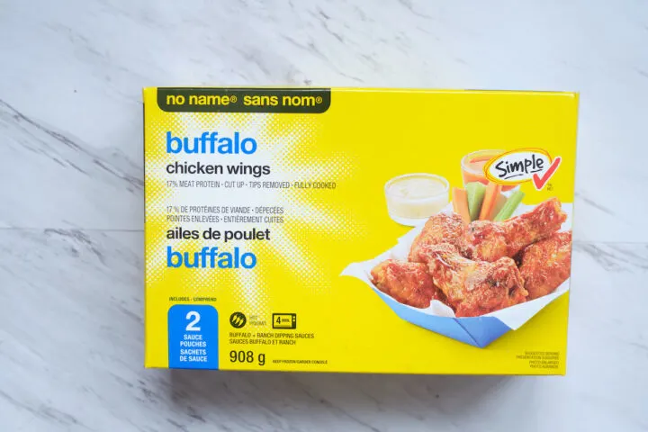 A box of no name frozen buffalo chicken wings on a white marble background